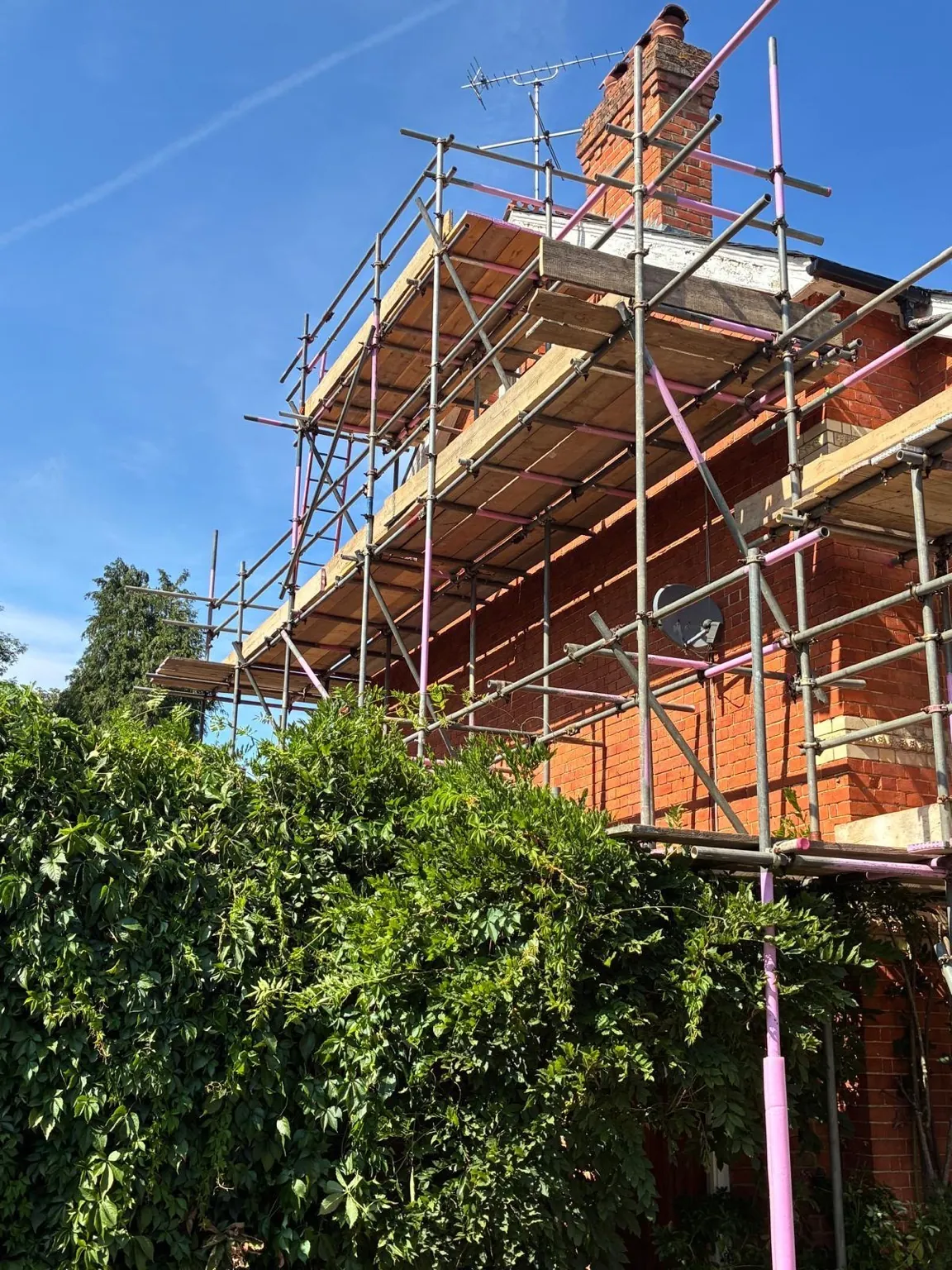 Multiple boarded working lifts stacked up to the chimney and roofline