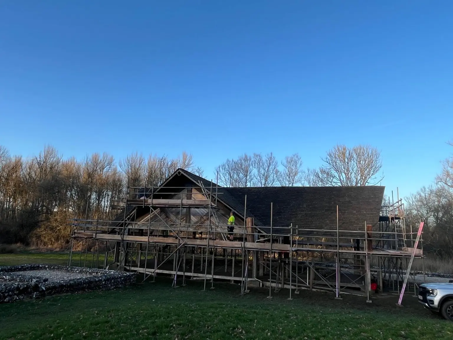 Long side elevation showing multi-level scaffolding around the timber Roman villa pavilion