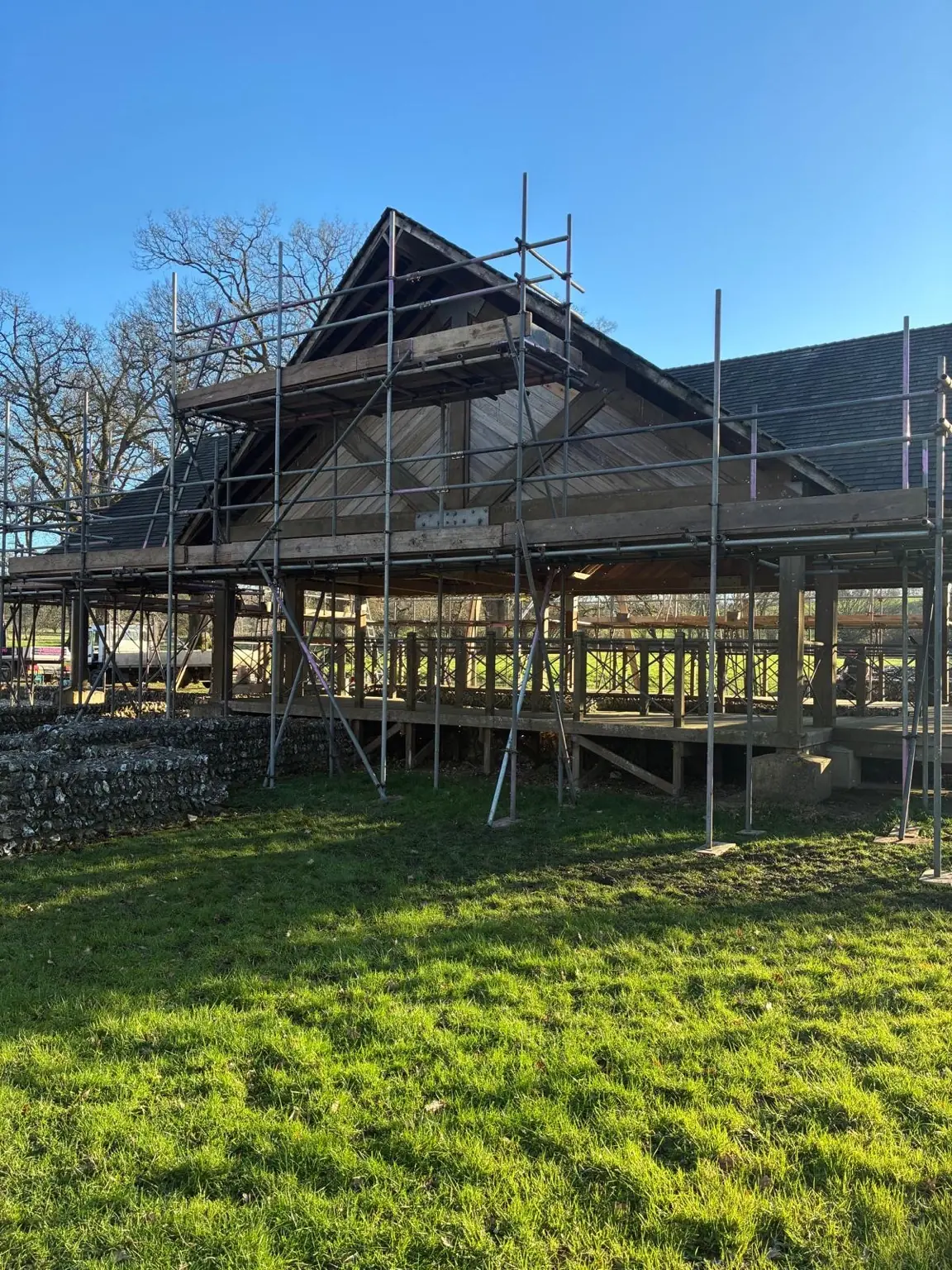 Gable-end scaffold with boarded lifts and guardrails around the Littlecote Roman Villa pavilion