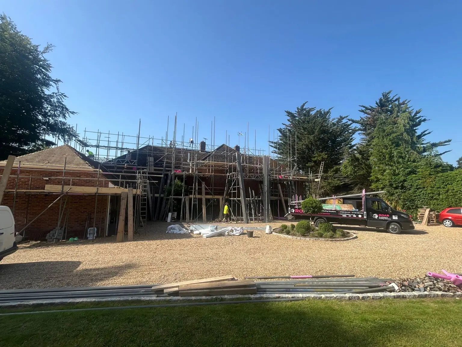 Wide site view of the renovation scaffold with ROAR vehicle and material access