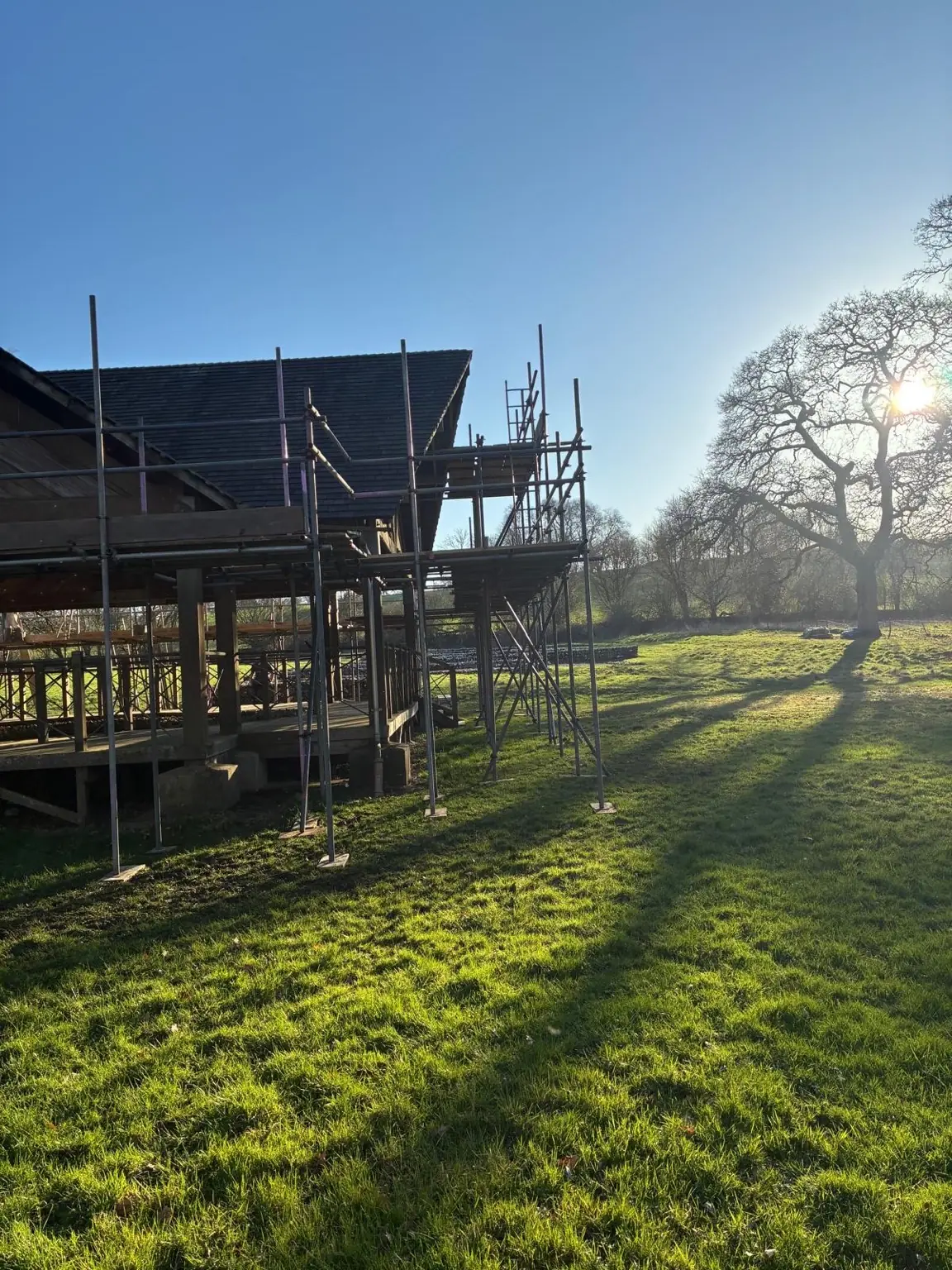 Scaffold surrounding the open-sided timber pavilion in the landscaped grounds at Littlecote Roman Villa
