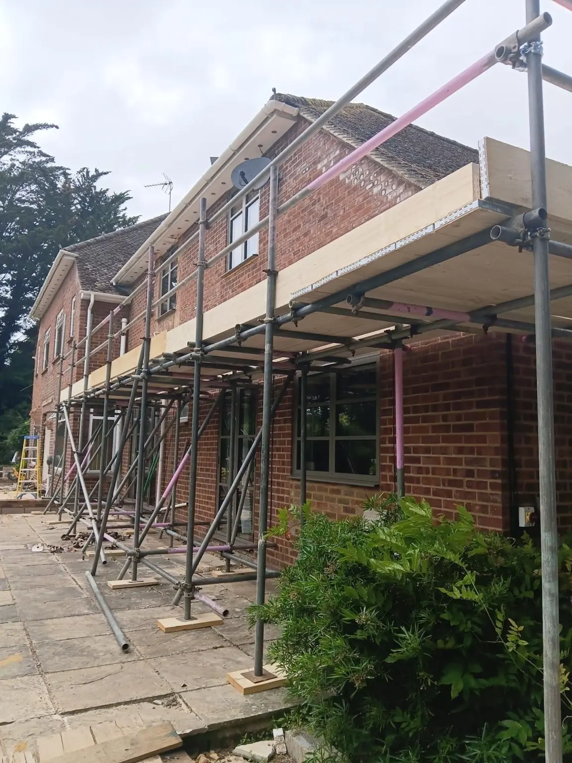Supported boarded platform providing material and working access beside the property