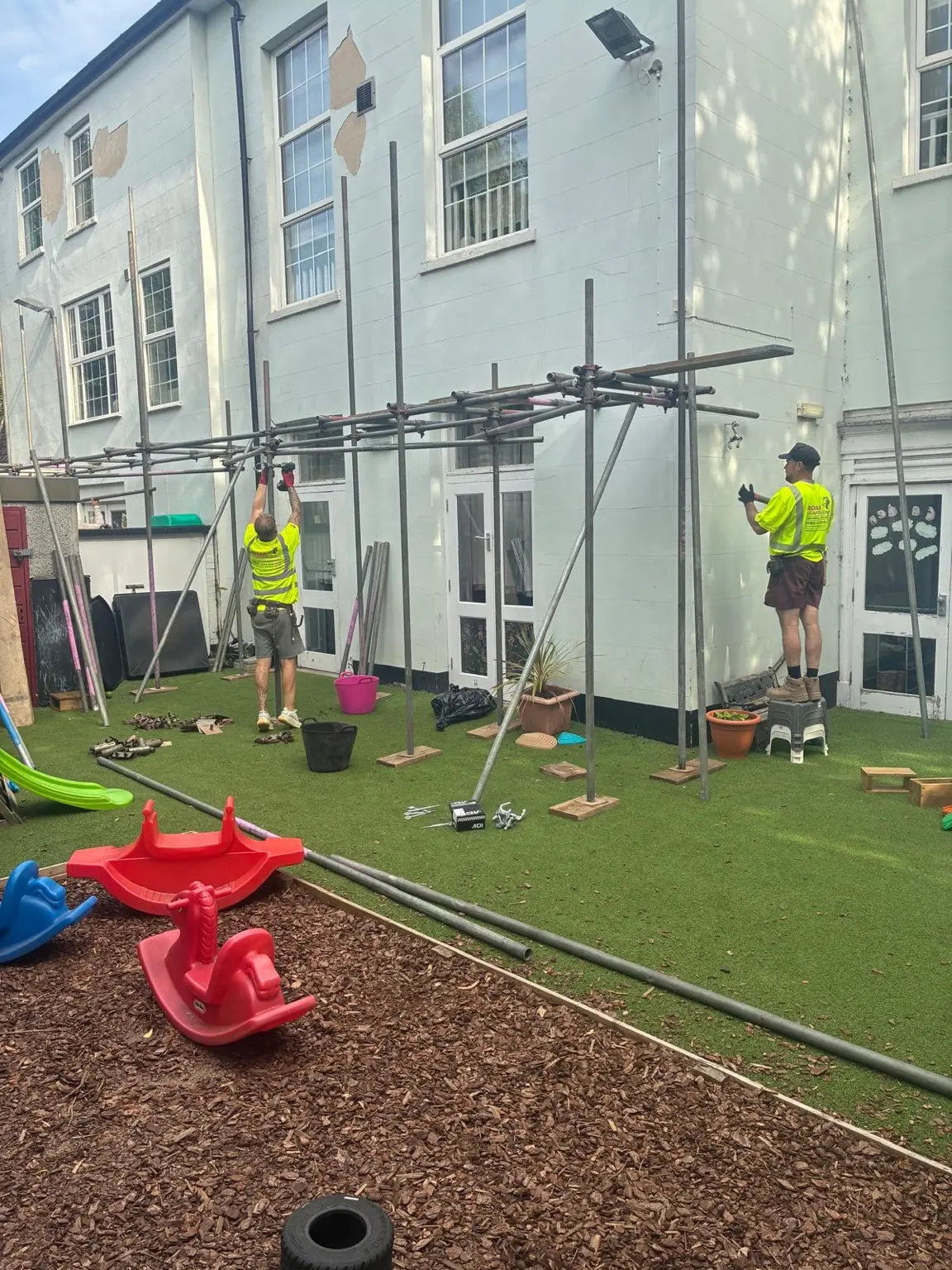 Scaffold operatives erecting access platforms around the nursery play area